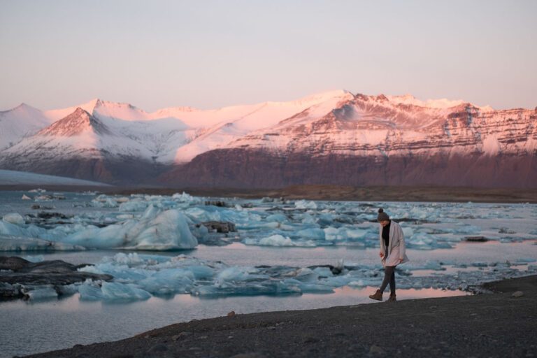 a traveler walking on the beach of Jokulsarlon Glacier Lagoon a traveler walking on the beach of Jokulsarlon Glacier Lagoon in winter at sunset