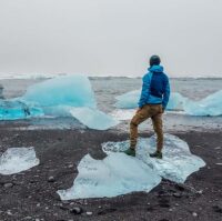 Iceland – Man standing on small ice bergs