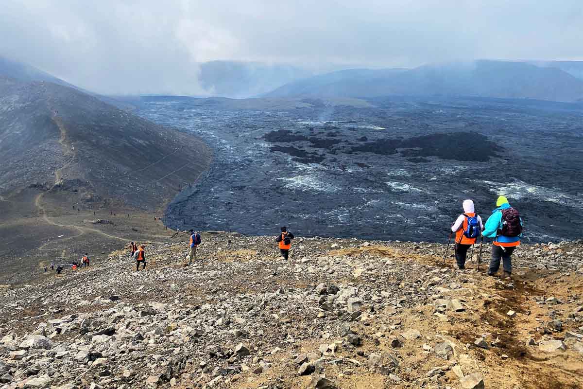 Hikers walking down mountain slope near Fagradalsfjall Volcano