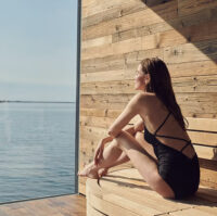 A woman in sauna with ocean view at Sky Lagoon