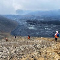 Hikers walking along the new lava field