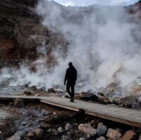 A man walking through steaming Seltun geothermal area