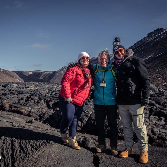 A guide and two guests standing on new lava at Fagradalsjall volcano