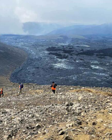 Hikers walking down mountain slope near Fagradalsfjall Volcano