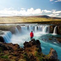 A visitor is standing and gazing at Godafoss waterfall in North Iceland