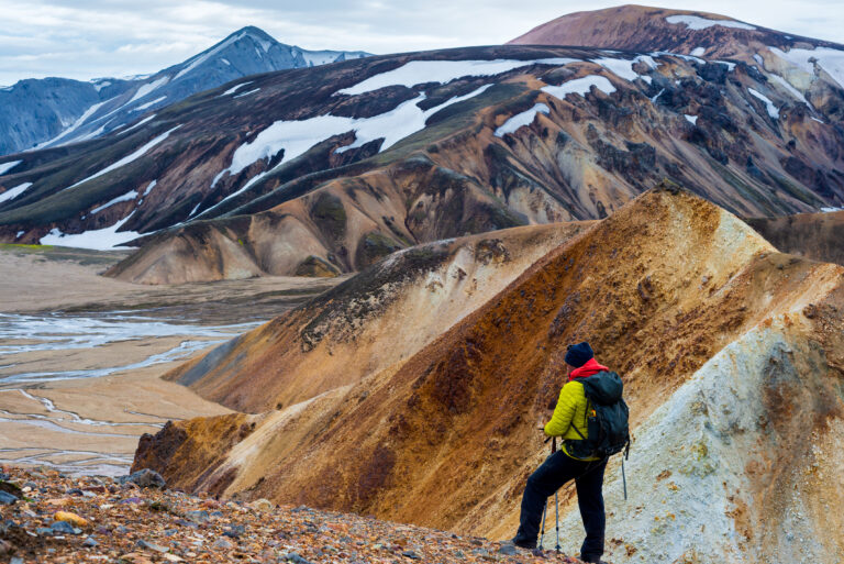Man hiker looking at the colorful mountain in Landmannalaugar, Iceland