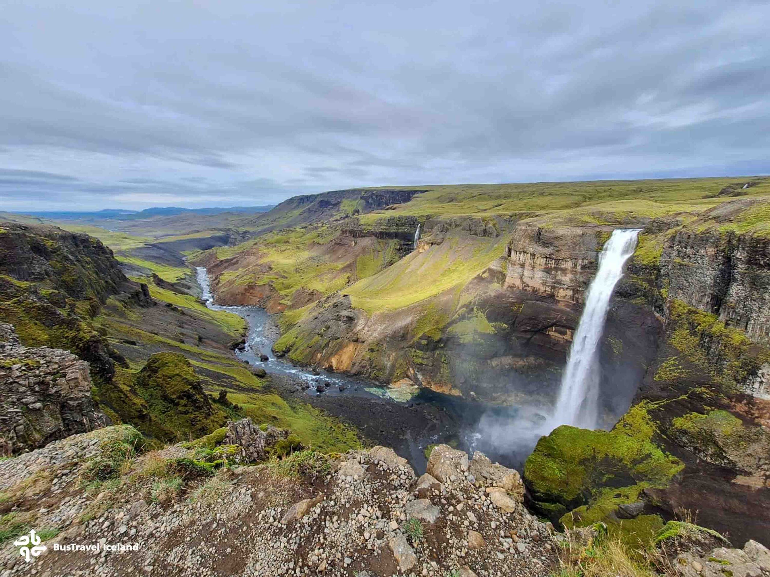 The Háifoss waterfall in Iceland streaming down a dramatic cliff into a deep valley surrounded by rugged landscape