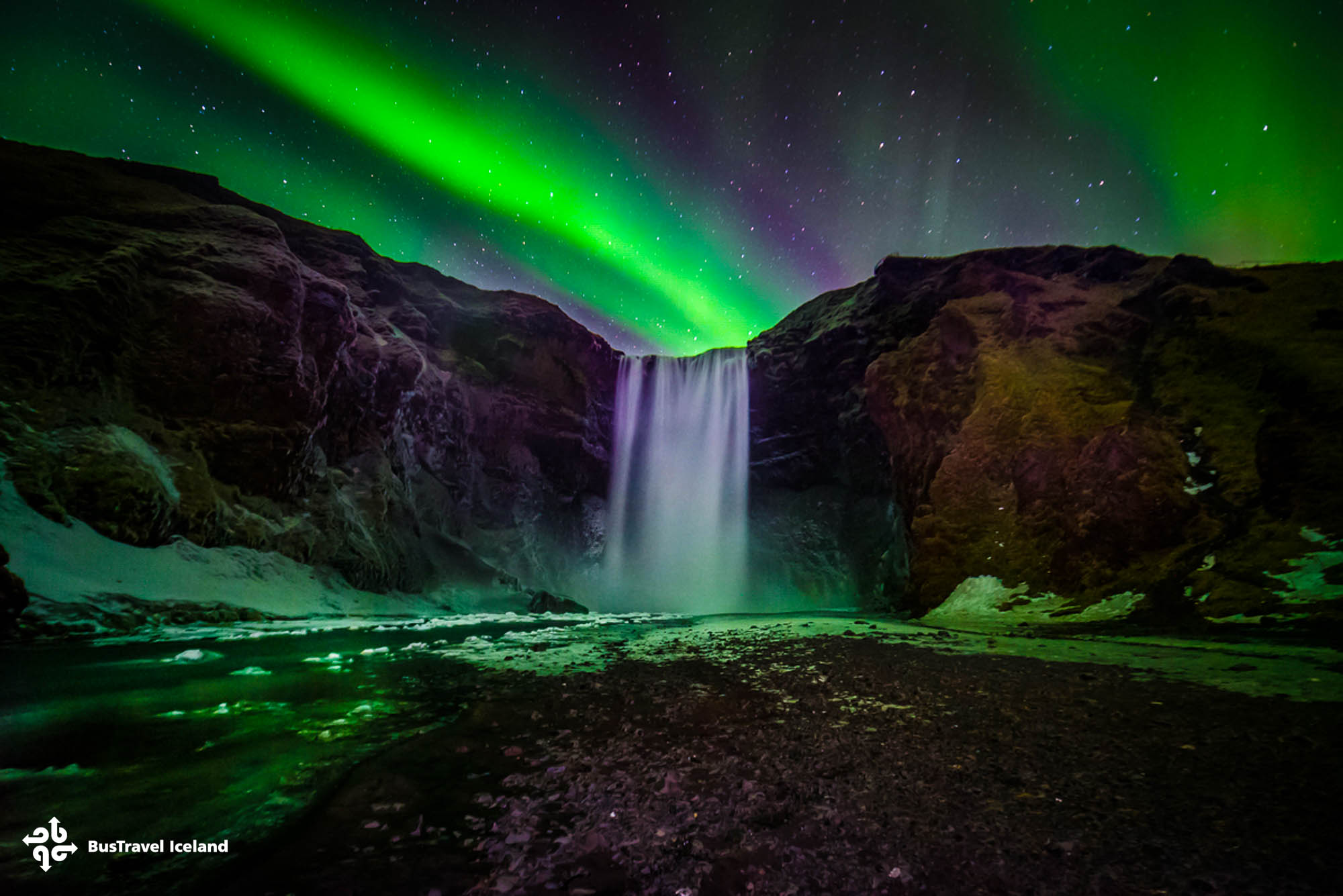 Skogafoss waterfall in South Iceland under the Northern Lights.